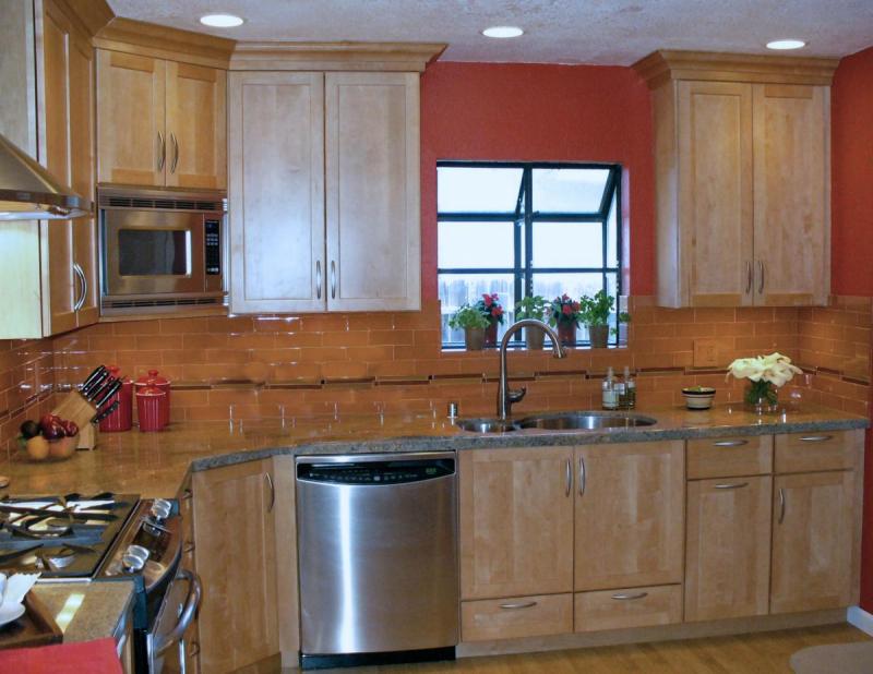 A budget friendly kitchen with maple wood cabinets and hand-made tiles