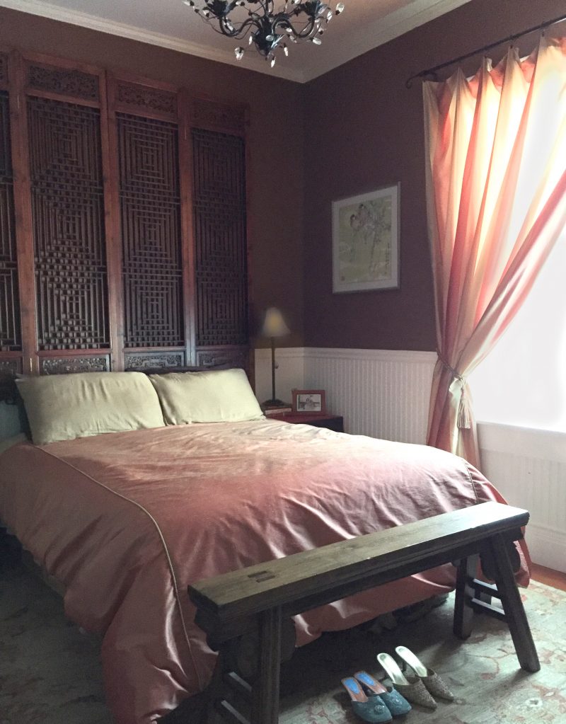 A master bedroom filled with rich color and antiques