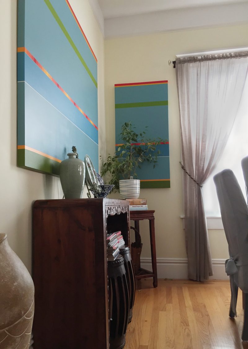 Colorful abstract paintings give life to this small dining room