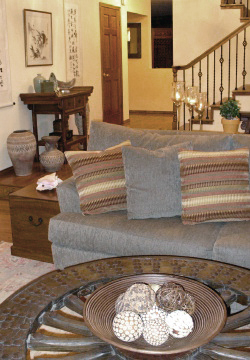 A warm, inviting living room incorporates a Chinese antique wagon wheel as a coffee table